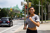 Fit young woman running on a busy city street