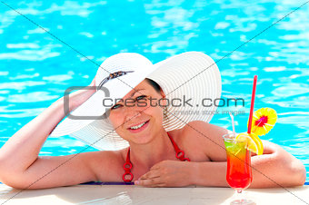 girl in a white hat relaxes in the pool