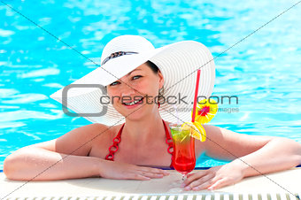 woman in the pool with a cocktail in a white hat