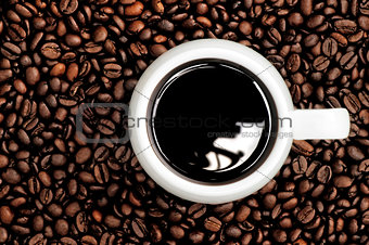 A cup of coffee on a background coffee grains