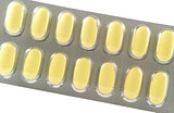 Closed up long yellow tablet in transparent blister pack