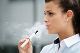 young woman smoking electronic cigarette outdoor office building