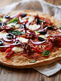Pizza with mozzarella, dried and fresh tomatoes