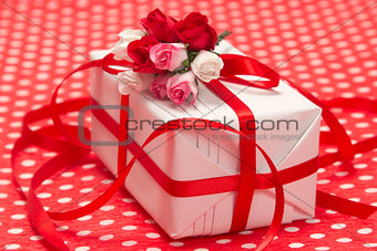 White gift box with red bow and paper flowers