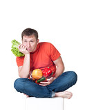 Young man with plate of fresh healthy vegetables