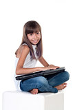 Cute little girl is sitting with laptop