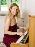 Beautiful blond playing the piano at home