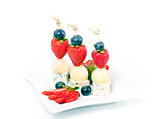 Canapes on a plate with cheese melon and strawberries