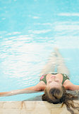 Young woman relaxing in pool . rear view