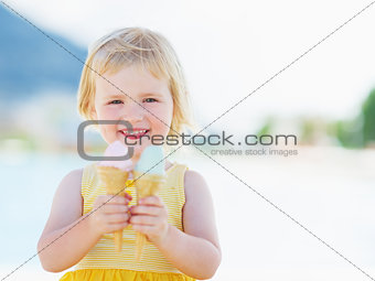 Smiling baby eating two ice cream horns