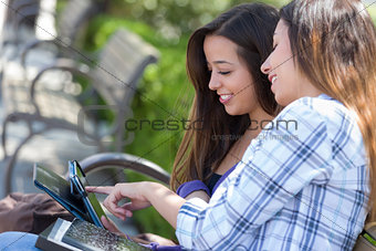 Two Mixed Race Students Using Touch Pad Computer Outside