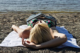 Young woman with a book sleeping on the beach