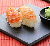 portion of sushi with shrimp on a stone plate