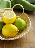 lemons and limes in a wicker basket on the table