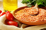 red lentils in a clay bowl on a wooden table