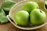green apples "Granny Smith" in a basket on the table