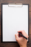 Clipboard with blank sheet of white paper and pen