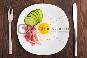 Fried egg with ham and cucumber