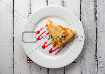 top view of folded pancake on white plate