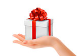 Gift box in hand with red bow and ribbons. Vector. 