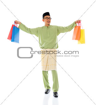 Traditional Malay male shopping and jumping in joy during hari r