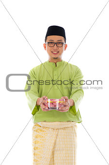 Traditional Malay male with biscuit during hari raya