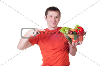 Young man with plate of fresh healthy vegetables