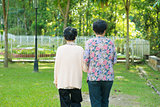Rear view Asian old mother and senior daughter walking at outdoo