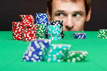 man looking under the table on playing chips