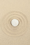 zen stone in sand with circles