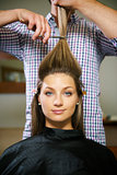 woman in hairdresser shop cutting long hair