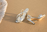 Ladies silver shoes on  a beach