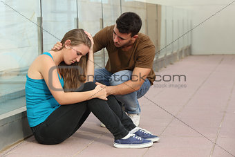 Beautiful teenager girl worried and a boy comforting her 