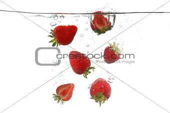 Strawberries Falling Into Splashing Clear Water