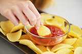 Closeup on girl putting chips in sauce