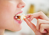 Closeup on happy young woman eating popcorn