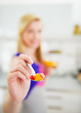 Closeup on young woman stretching spoon with salad in camera