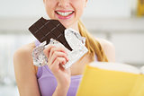 Closeup on teenager girl with book and chocolate bar