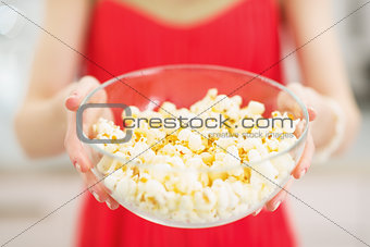 Closeup on plate with popcorn in hand of young woman