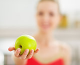 Closeup on apple in hand of young woman