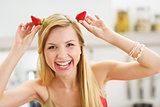 Smiling young woman making horns with strawberries