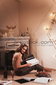 young woman sitting and reading magazine indoor shot