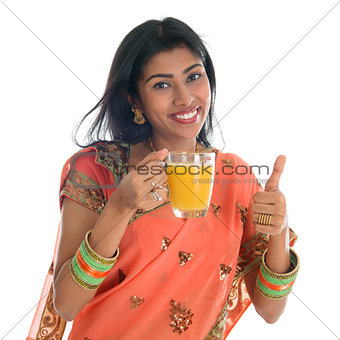 Thumb up Indian woman drinking orange juice