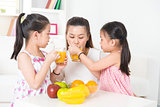 Asian parent and children drinking orange juice