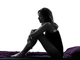 woman sad despair sitting in bed silhouette