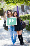 Mixed Race Female Students Holding Chalkboard With A+ Written