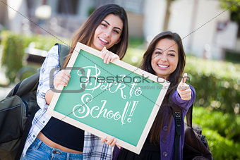 Mixed Race Female Students Holding Chalkboard With Back To Schoo