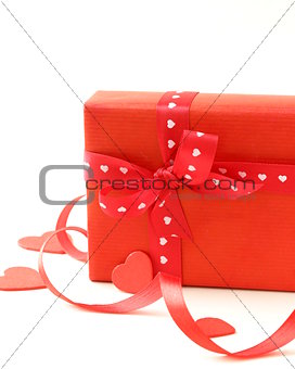 red gift box with ribbon and hearts on a white background