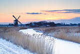 Dutch windmill in winter at sunrise