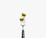 olive pierced by fork,  isolated on white background 